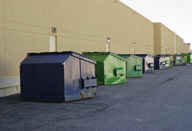 a pile of demolition waste sits beside a dumpster in a parking lot in Bee Spring KY